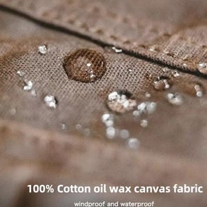 May include: Close-up of a brown cotton oil wax canvas fabric with water droplets. The fabric is windproof and waterproof. The text "100% Cotton oil wax canvas fabric" is visible at the bottom of the image.