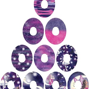 Puede incluir: Conjunto de diez pegatinas redondas con una variedad de diseños que presentan un esquema de color morado, rosa y blanco. Los diseños incluyen una galaxia, estrellas y hadas.