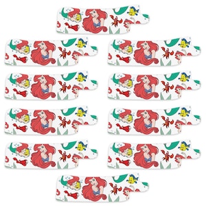 May include: Eight colorful printable stickers featuring Ariel, the Little Mermaid, with a red tail, yellow hair, and a purple seashell bra. The stickers also feature Flounder, Sebastian, and other sea creatures.