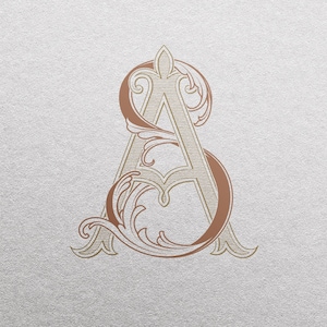以下が含まれることがあります： 「A」と「S」の文字が、装飾的な花飾りで絡み合ったモノグラムのデザイン。文字は白で縁取られた茶色です。