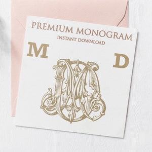 以下が含まれることがあります： 「PREMIUM MONOGRAM INSTANT DOWNLOAD」というテキストと、金色の「M」と「D」の文字が書かれた白いカード。 「M」の文字は大きく、装飾的なフォントで書かれており、装飾的なデザインで囲まれています。