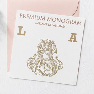 May include: A white card with the text "PREMIUM MONOGRAM INSTANT DOWNLOAD" in gold lettering. The letters "L" and "A" are also in gold lettering. A gold monogram design with the letters "LA" is in the center of the card.