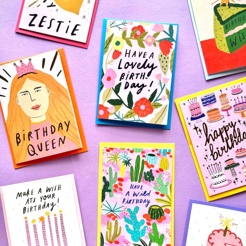 May include: A collection of colorful birthday cards with various designs and text. One card features a woman with a crown and the words "BIRTHDAY QUEEN." Other cards say "Have a Lovely Birth Day!" and "Happy Birthday."