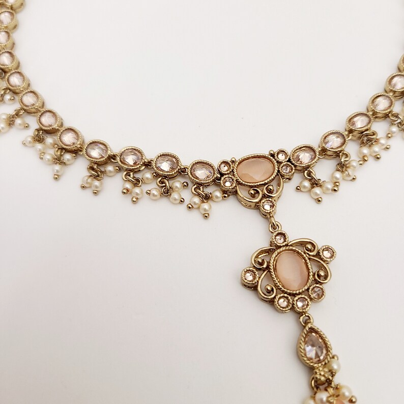 22k Gold plated IndianSouth Asian designed necklace set with gold zircon diamonds and peach accents Comes with matching earrings and tikka