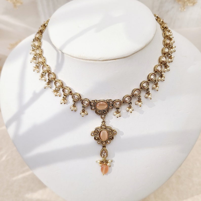 22k Gold plated IndianSouth Asian designed necklace set with gold zircon diamonds and peach accents Comes with matching earrings and tikka