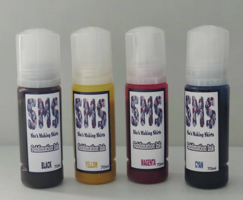 May include: Four bottles of sublimation ink in black, yellow, magenta, and cyan. Each bottle is labeled "SMS She's Making Shirts Sublimation Ink" and the color of the ink. The bottles are 70 ml each.