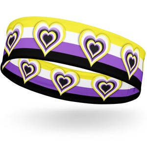 May include: A yellow, white, purple, and black headband with a repeating pattern of hearts. The hearts are layered with black, yellow, white, and purple.
