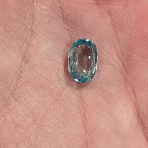 K&ouml;nnte beinhalten: Ein ovaler, blauer Edelstein mit Facettenschliff.