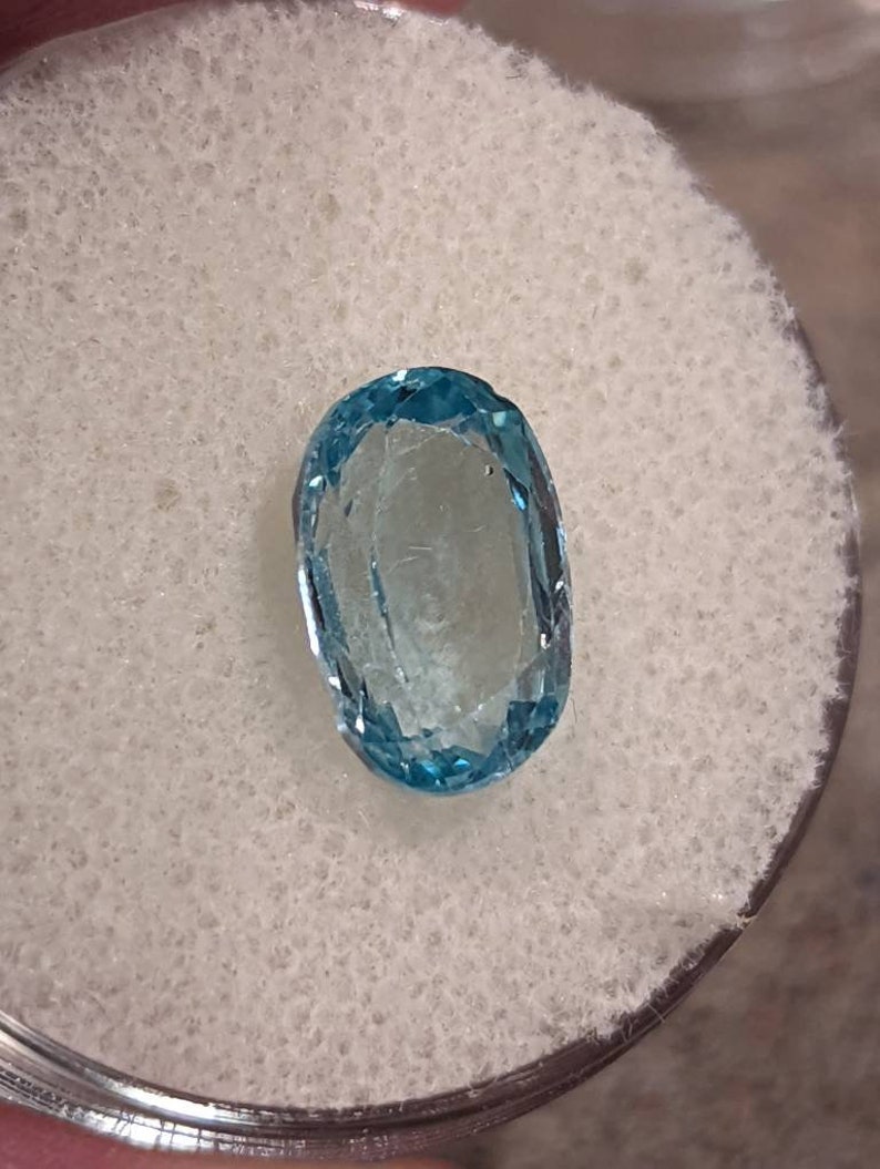 K&ouml;nnte beinhalten: Ein ovaler, hellblauer Edelstein mit einem leichten Schimmer.
