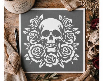 Op de afbeelding: Een vierkant sjabloon met een wit grafisch ontwerp van een menselijke schedel omringd door een krans van bloeiende rozen en bladeren op een donkergrijze achtergrond. Het ontwerp is gecentreerd op het vierkante vel en toont gedetailleerde vormen.