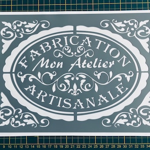 Puede incluir: Plantilla blanca sobre fondo gris con el texto "FABRICATION Mon Atelier ARTISANALE" en una fuente decorativa.