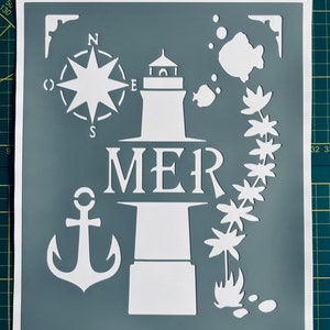 May include: A white stencil on a gray background with a lighthouse, anchor, compass, fish, and palm trees. The word "MER" is written below the lighthouse.
