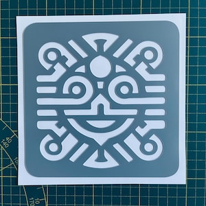 Puede incluir: Un esténcil cuadrado con un diseño simétrico en gris y blanco. El diseño se compone de formas geométricas, incluyendo círculos, líneas y curvas, creando un patrón abstracto. El esténcil está sobre un respaldo blanco.
