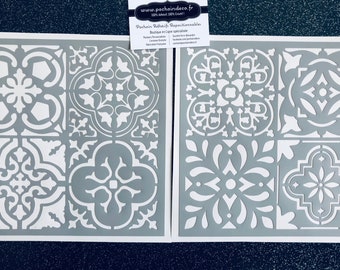 Op de afbeelding: Twee grijze herbruikbare sjablonen met ingewikkelde witte tegelpatronen. De sjablonen zijn gemaakt van duurzaam materiaal en zijn perfect voor het creëren van prachtige tegelontwerpen op muren, vloeren en meubels.