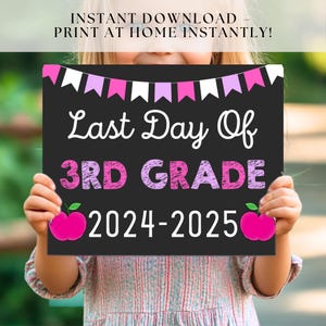May include: A black chalkboard sign with pink and white bunting at the top. The sign says "Last Day Of 3rd Grade 2024-2025" with pink and white lettering and two pink apples on either side of the year.