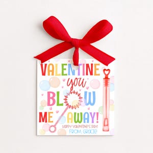 May include: A Valentine's Day gift tag with a red ribbon bow. The tag features colorful text that reads "VALENTINE, you BLOW ME AWAY!" with bubble graphics and a bubble wand illustration. The text "Happy Valentine's Day! From, Gracie" is also included.