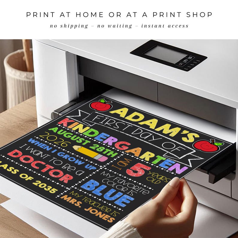 May include: A printed sign on black paper emerging from a white printer. The text reads: ADAM'S FIRST DAY OF KINDERGARTEN AUGUST 28TH 2026, I AM 5 YEARS OLD, WHEN I GROW UP I WANT TO BE A DOCTOR, MY FAVORITE COLOR IS BLUE, CLASS OF 2035, MRS. JONES.