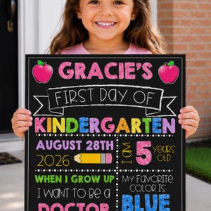 Op de afbeelding: Een zwart krijtbord met kleurrijke tekst en afbeeldingen met de tekst Gracie's First Day of Kindergarten, August 28th 2026, I am 5 years old, I want to be a doctor, my favorite color is blue, my teacher is Mrs. Jones en Class of 2035.