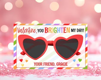 May include: A colourful Valentine's Day card with a red heart-shaped sunglasses graphic. The card reads "Valentine, you brighten my day!" and "Your friend, Gracie".