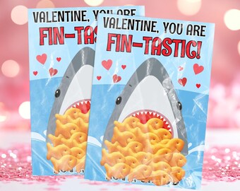 May include: Two Valentine's Day cards featuring a cartoon shark with a mouth full of goldfish crackers. The text on the cards reads "Valentine, you are fin-tastic!"