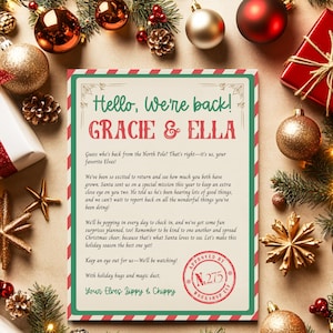 May include: A festive Christmas card with a red and green border, featuring the text "Hello, We're back!" and the names "GRACIE & ELLA." The card is surrounded by Christmas ornaments and holiday decorations.