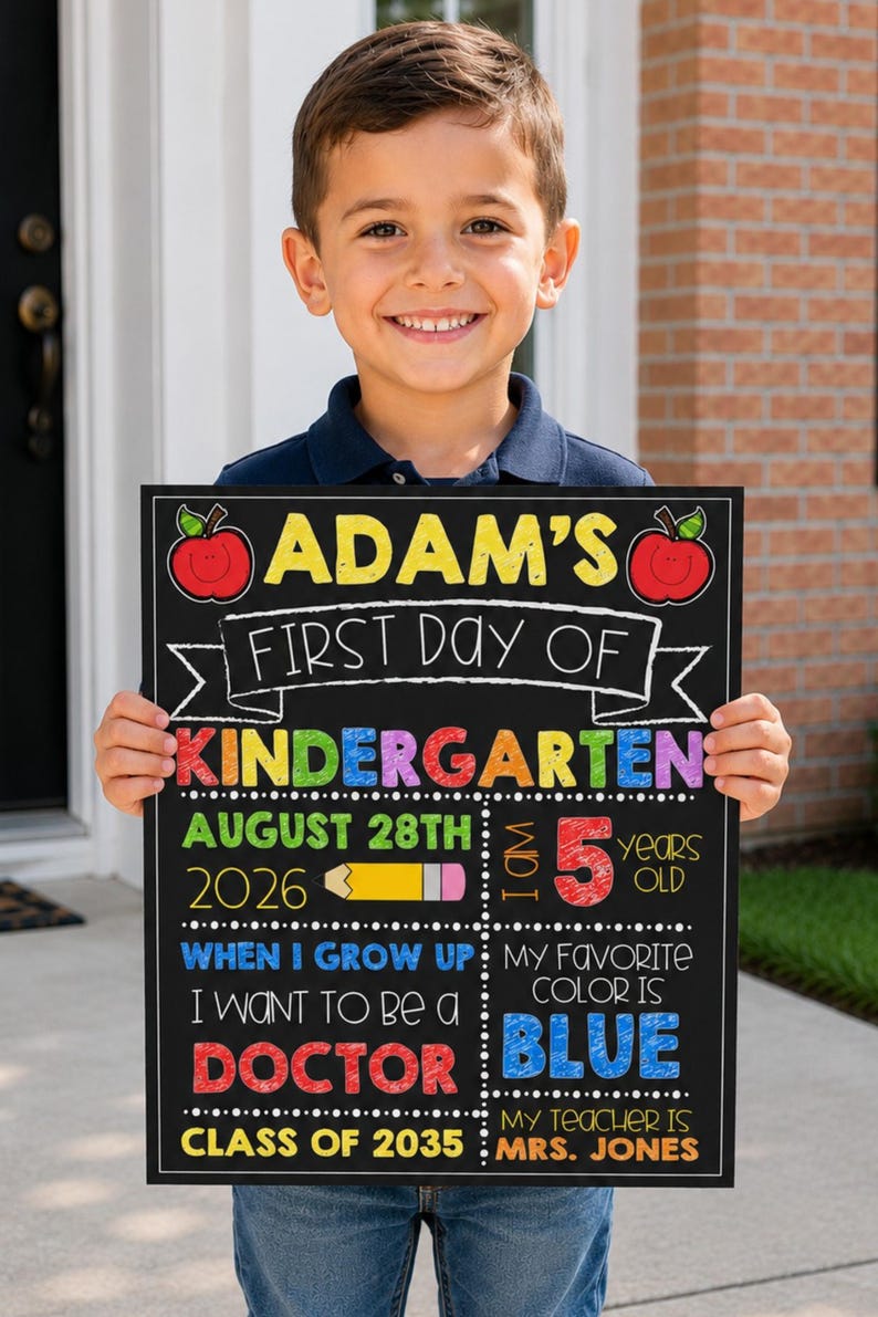 May include: A rectangular chalkboard sign for the first day of kindergarten featuring colorful text and graphics including apples, a pencil, and the name Adam. The sign displays details like the date August 28th 2026, age 5, career goal doctor, favorite color blue, and teacher Mrs. Jones.