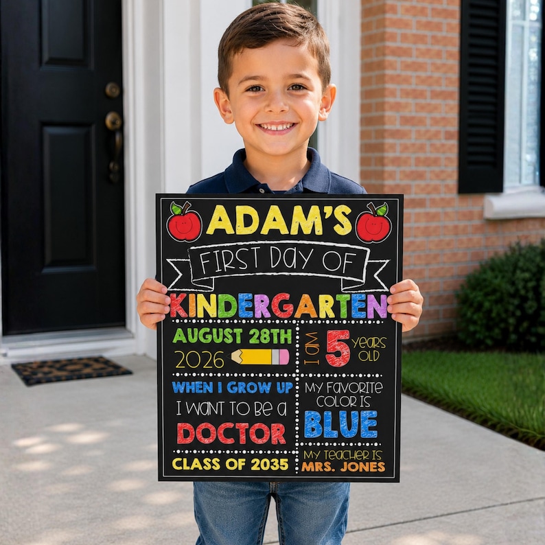 May include: A rectangular chalkboard sign with colorful text and graphics. It reads: ADAM'S FIRST DAY OF KINDERGARTEN, AUGUST 28TH 2026, I AM 5 YEARS OLD, WHEN I GROW UP I WANT TO BE A DOCTOR, MY FAVORITE COLOR IS BLUE, MY TEACHER IS MRS. JONES, CLASS OF 2035.