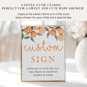 Op de afbeelding: Een wit bord met een gouden lijst en een illustratie van sinaasappelen. Het bord zegt "custom sign" en "enter any of your own text and create an unlimited number of signs!"