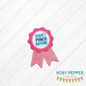 May include: Pink embroidered iron-on patch with a pink ribbon and a white circle with the text "Didn't Punch Anyone" in blue and white lettering.