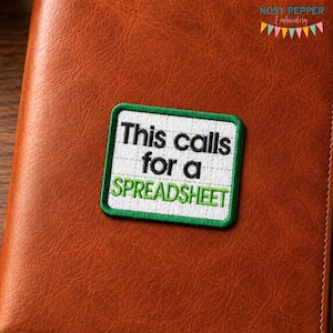 May include: A rectangular embroidered patch with a white background and a green border. The patch features a grid pattern and black text that reads This calls for a, followed by the word SPREADSHEET in green capital letters.
