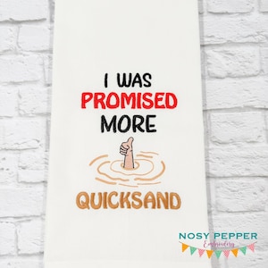 May include: A white kitchen towel featuring black and red embroidered text that reads I WAS PROMISED MORE QUICKSAND, accompanied by an embroidered graphic of a hand giving a thumbs up while sinking into tan-coloured quicksand.