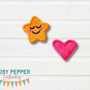 Pode incluir: Dois patches bordados em um fundo de madeira branca. O primeiro patch é uma estrela amarela com um rosto sorridente. O segundo patch é um coração rosa.