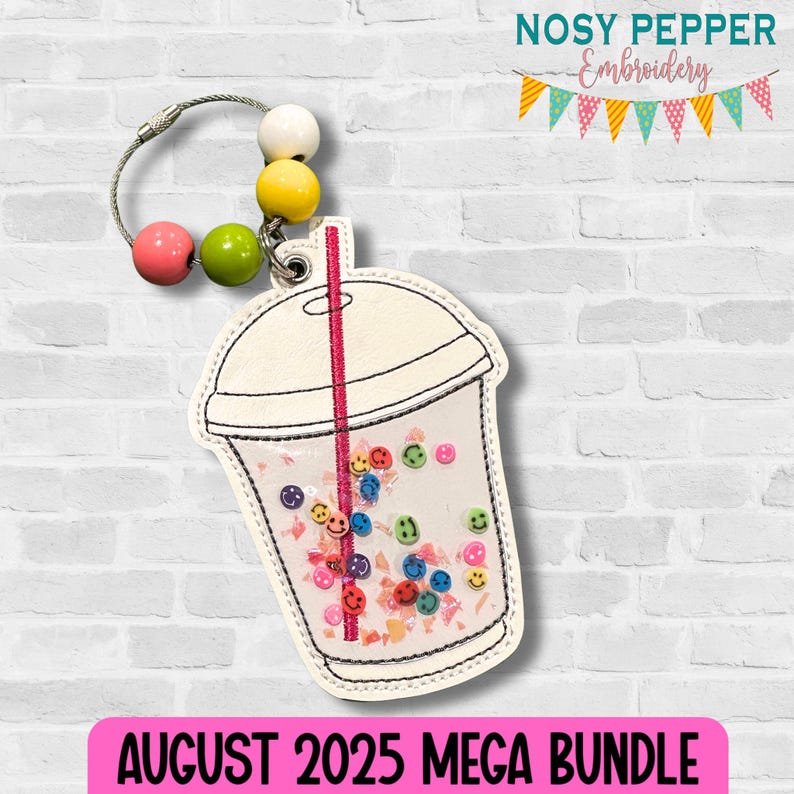 May include: A white and clear keychain shaped like a bubble tea cup, filled with colorful smiley face sequins. The keychain has a pink and red straw, and a beaded loop with pink, green, yellow, and white beads. The text "AUGUST 2025 MEGA BUNDLE" is at the bottom.
