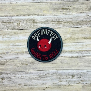May include: A black and white embroidered patch with a red devil face and the text "Definitely Going To Hell".