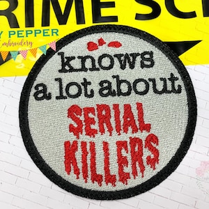 May include: A round, gray embroidered patch with black stitching. The text "knows a lot about SERIAL KILLERS" is embroidered in red with dripping blood effects.