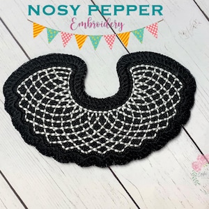 Può includere: Design di colletto ricamato in bianco e nero, che ricorda un tradizionale abito legale. Il design è su uno sfondo di tessuto nero.