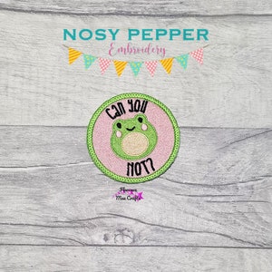 May include: A pink and green embroidered patch with a cartoon frog and the text "Can you not?"