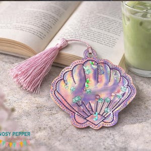 May include: A white ceramic mug with a black handle and the text "But First, Coffee" in a black, handwritten-style font. The mug is on a white surface.