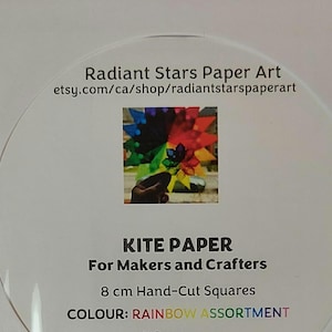 Peut inclure: Une étiquette de produit circulaire pour Radiant Stars Paper Art avec une image centrale d'un artisanat en papier en forme d'étoile multicolore. Le texte indique : Radiant Stars Paper Art, etsy.com/ca/shop/radiantstarspaperart, KITE PAPER, For Makers and Crafters, 8 cm Hand-Cut Squares, COLOUR: RAINBOW ASSORTMENT.