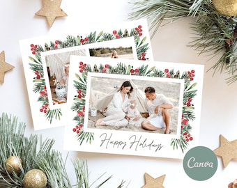 May include: A Christmas card with a watercolor border of pine branches and red berries. The card features a photo of a family of three standing on a beach with the text "Happy Holidays" printed below the photo.