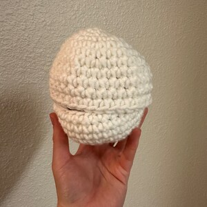 Puede incluir: Un gorro blanco de ganchillo con un borde doblado.