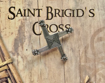 May include: A silver Saint Brigid's Cross, a traditional Irish symbol, on a wooden background with the text "Saint Brigid's Cross" above it.