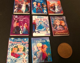 Può includere: Una collezione di nove libri tascabili in miniatura con personaggi del film Disney Frozen. I libri hanno copertine colorate con immagini di Elsa, Anna, Olaf e Kristoff. I titoli includono "Frozen II", "Frozen", "Frozen Tutti amano Olaf", "Frozen Lascia andare", "Frozen II La foresta incantata", "Frozen Magia di Natale", e "Frozen".