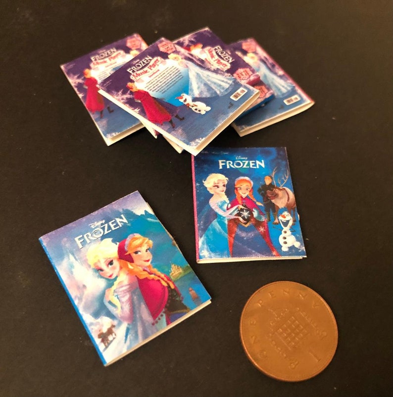 以下が含まれることがあります： エルサとアナのキャラクターをフィーチャーしたミニチュア版のアナと雪の女王の書籍セット。書籍は、ディズニーのアナと雪の女王のロゴとキャラクターの画像が描かれた青と紫の表紙です。