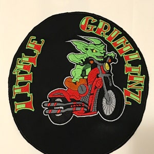 K&ouml;nnte beinhalten: Ein gestickter schwarzer und roter Aufn&auml;her mit einem gr&uuml;nen Kobold, der ein Motorrad f&auml;hrt. Der Aufn&auml;her zeigt links "Little" und rechts "Grinlinz".