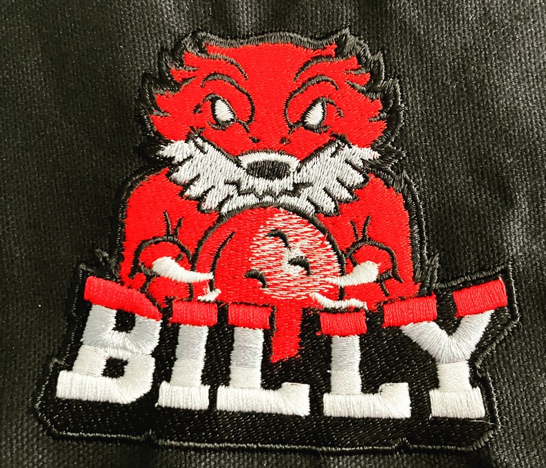 K&ouml;nnte beinhalten: Gestickter Aufn&auml;her mit einem roten Comic-Fuchs, der einen roten Ball h&auml;lt, mit dem Wort "BILLY" in wei&szlig;en Buchstaben auf schwarzem Hintergrund.