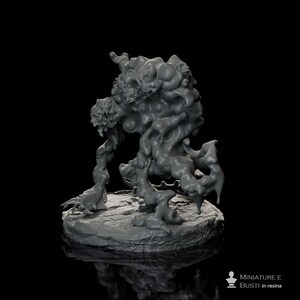 Puede incluir: Miniatura de resina gris de una criatura monstruosa con una forma grotesca y amorfa. La figura se alza sobre una base texturizada, con una superficie detallada. El cuerpo de la criatura es una masa de formas orgánicas arremolinadas. El texto "MINIATURE E BUSTI in resina" es visible.