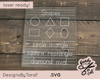 May include: A clear plastic sheet with white outlines of different shapes, including a circle, triangle, square, rectangle, diamond, and oval. The words "Shapes", "circle", "triangle", "square", "rectangle", "diamond", and "oval" are written below the shapes. The text "laser ready!" is at the top of the sheet. The text "DesignsByTaraF .SVG" is at the bottom of the sheet. A white sticker with a pair of scissors and the text "Ready to cut" is in the bottom right corner.