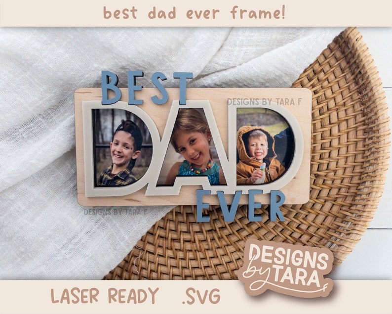 May include: A wooden frame with the words "Best Dad Ever" in blue letters. The frame has three photo slots, each with a picture of a child. The frame is on a woven basket.