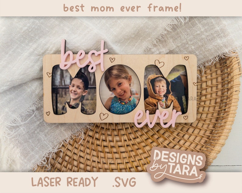 May include: A wooden frame with the words "best mom ever" in pink lettering. The frame has three cut-out spaces for photos. The frame is laser ready and comes with an SVG file.